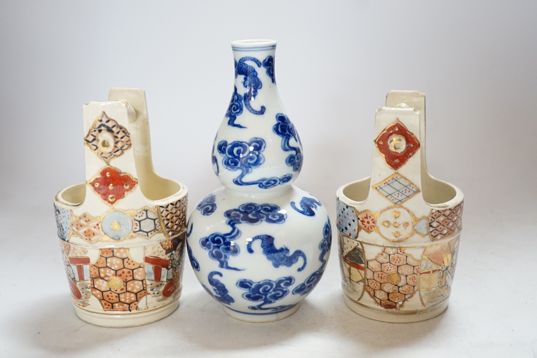 A Chinese blue and white double gourd vase and two Japanese Satsuma baskets, tallest 16cm